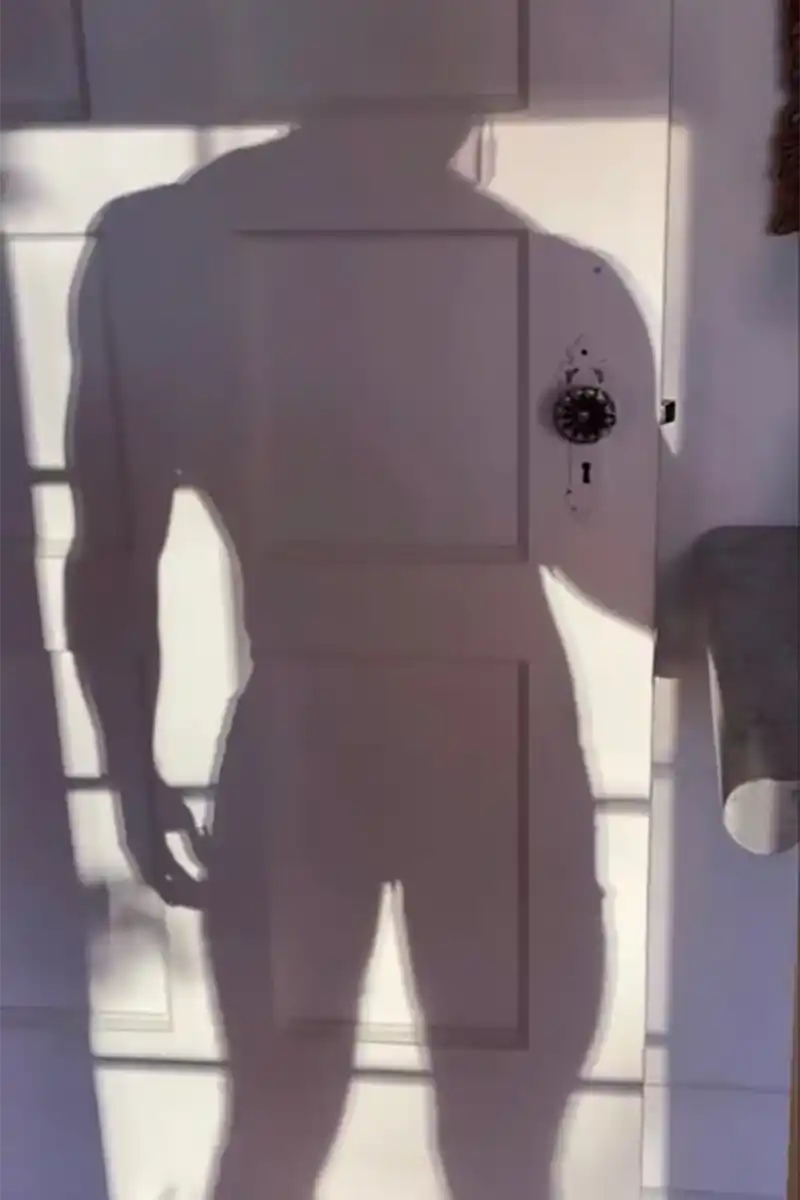 ombra di un uomo che sta in piedi in camera da letto